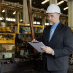 Gestor industrial analisando apólice de seguro ambiental com documentos de licenciamento