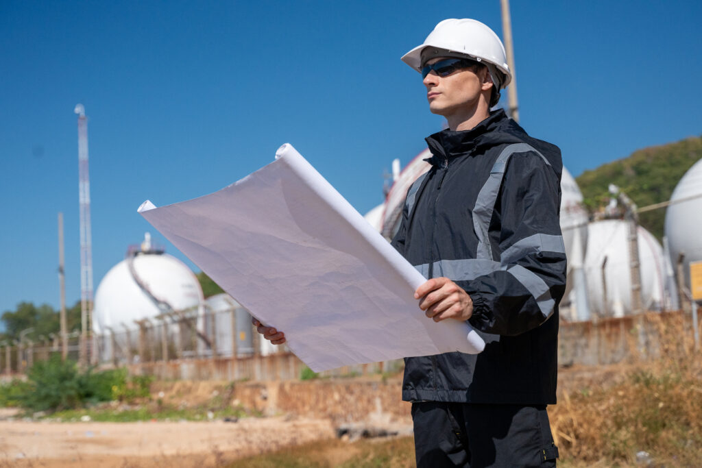 Engenheiro ambiental analisando planta tecnica em instalacao industrial para elaboracao do PGRS