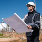 Engenheiro ambiental analisando planta tecnica em instalacao industrial para elaboracao do PGRS