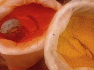 Pó de açafrão e pimenta em mercado, ilustrando matéria-prima de especiarias