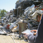 Supervisor com tablet digital em usina de reciclagem de sucata — PGRS industrial gestão de resíduos CETESB
