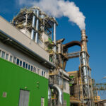 Vista de fábrica industrial com estrutura verde — sistema de gestão ambiental ISO 14001 em indústrias