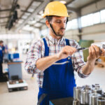 Técnico de manutenção industrial manuseando óleo lubrificante e filtros usados com EPIs adequados