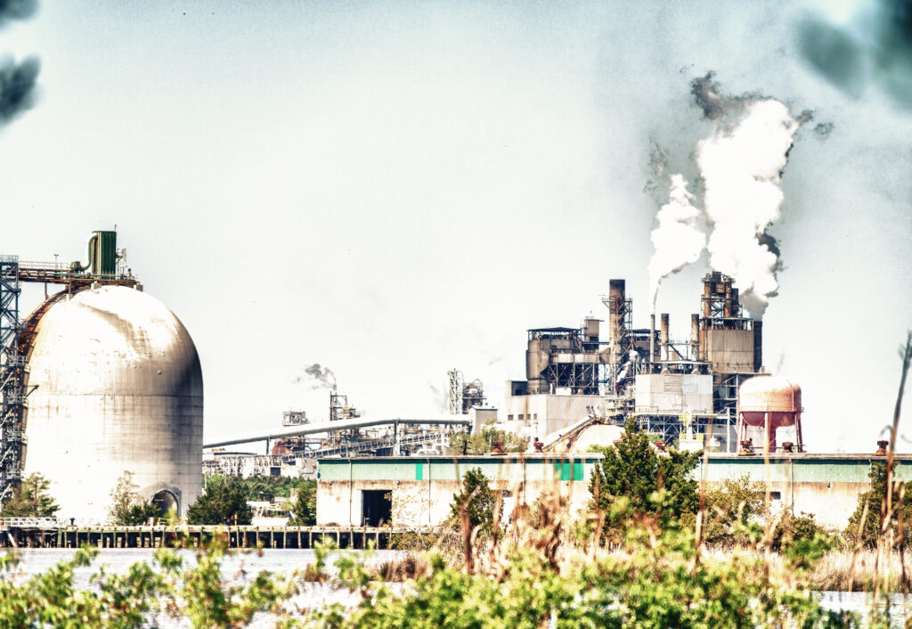 Usina elétrica em distrito industrial com emissões visíveis — contexto de empreendimentos que exigem EIA/RIMA no licenciamento ambiental