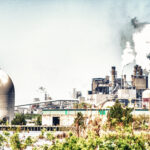 Usina elétrica em distrito industrial com emissões visíveis — contexto de empreendimentos que exigem EIA/RIMA no licenciamento ambiental