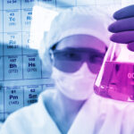 Cientista em laboratório químico industrial com máscara e tampa protetoras examinando tubo de ensaio — gestão de resíduos laboratoriais Classe I